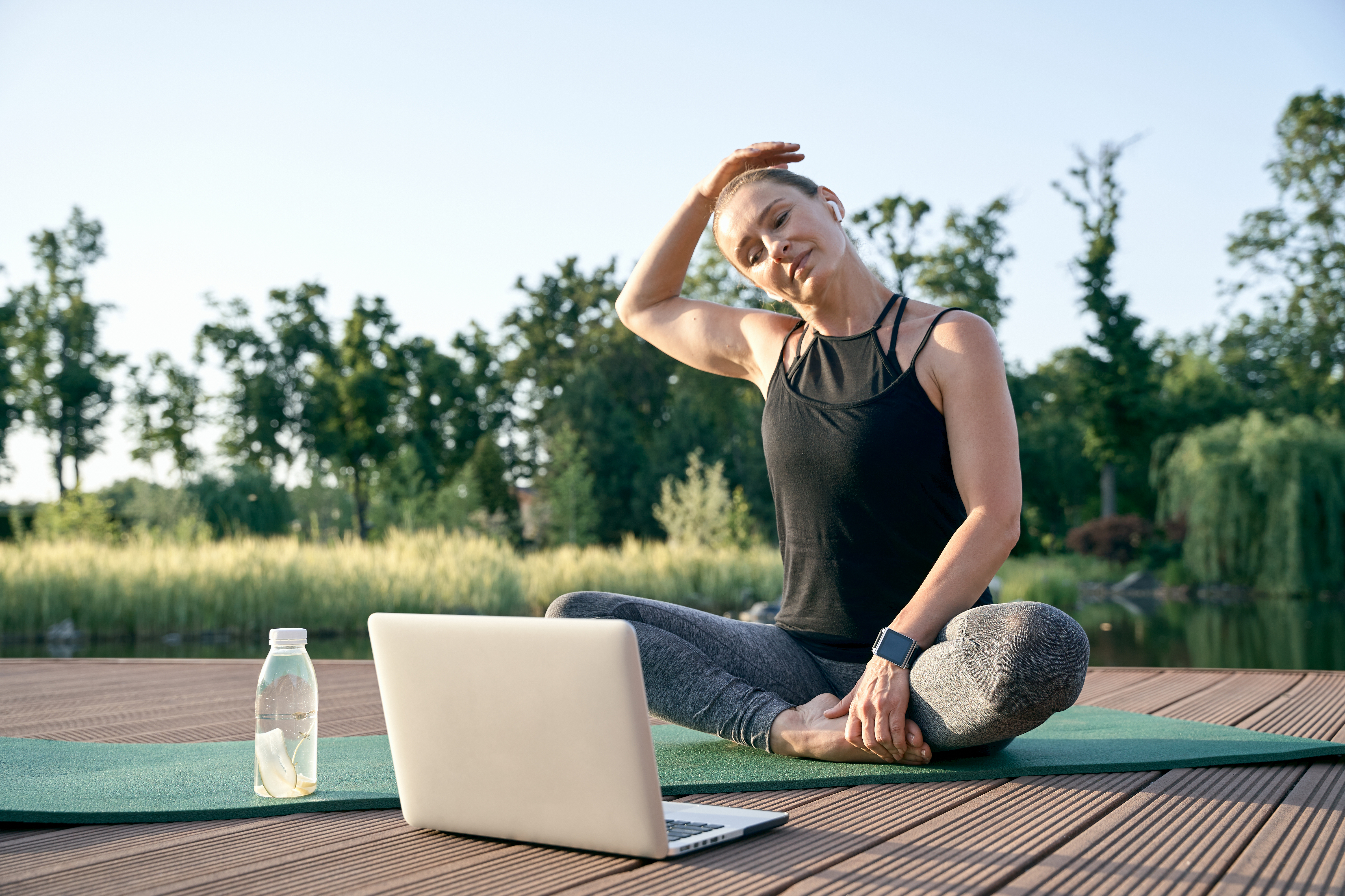 Calm your mind. Athletic beautiful middle aged woman watching instructional videos on a laptop