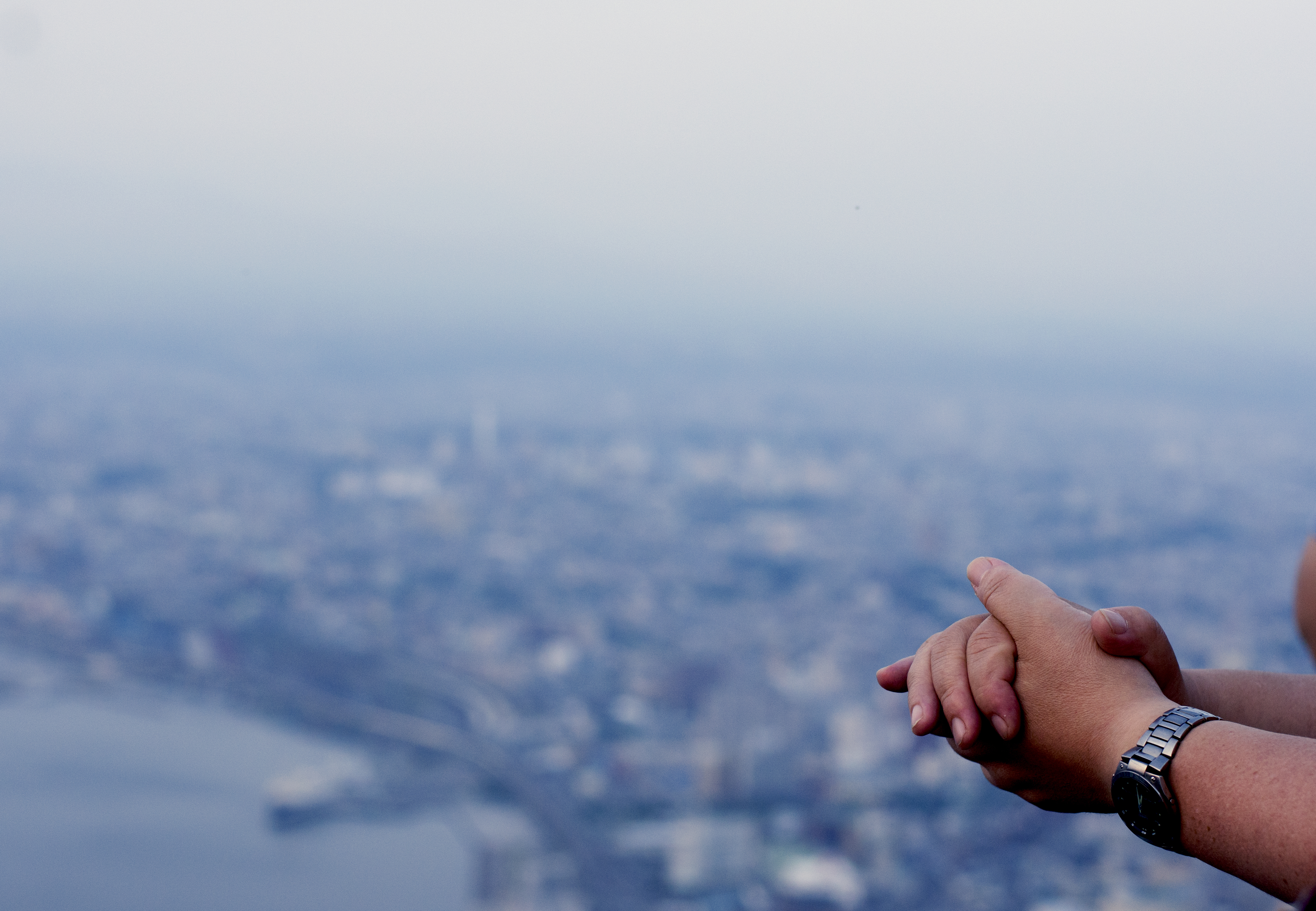 The hands of a tourist as he overlooks the early stages of the night view of Hakodate, Japan.